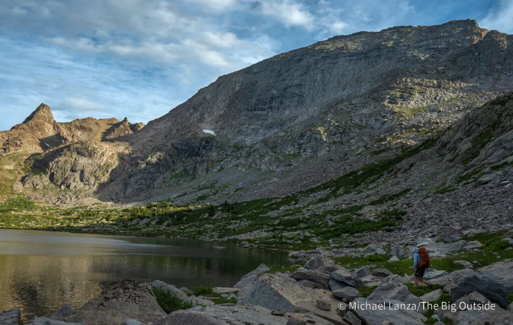 A backpacker hiking around Pyramid Lake in the Wind River Range, Wyoming.