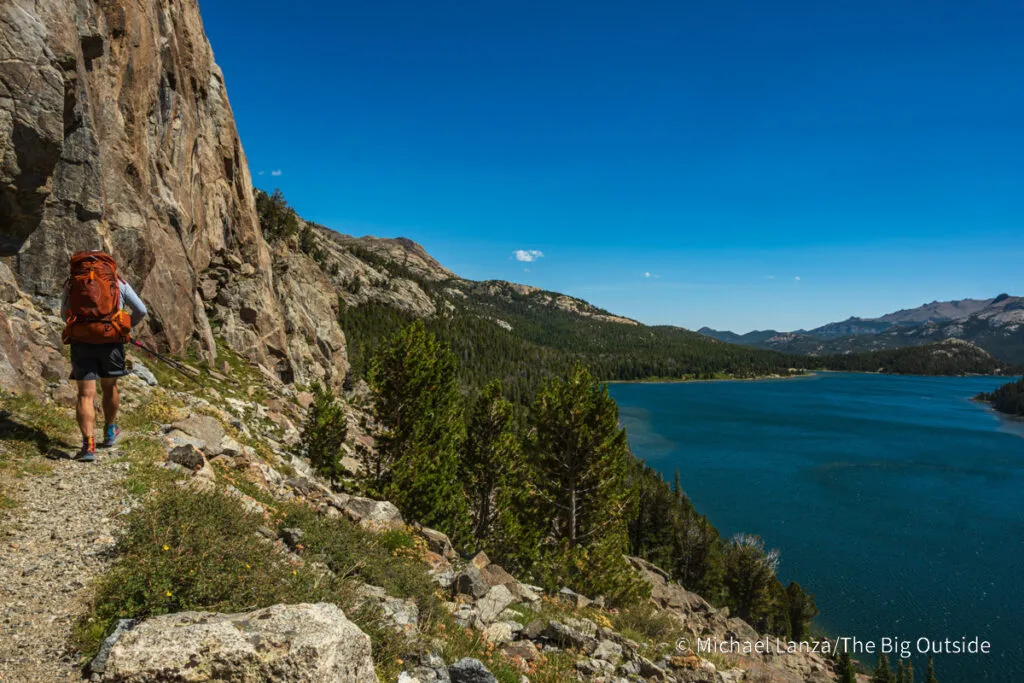 A backpacker hiking the Bears Ears Trail above Grave Lake in the Wind River Range, Wyoming.