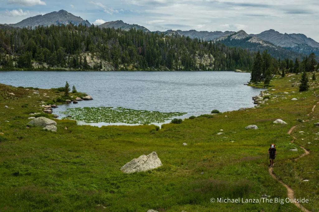 A backpacker hiking the CDT past Dads Lake while Backpacking Wyoming in the Wind River Range.