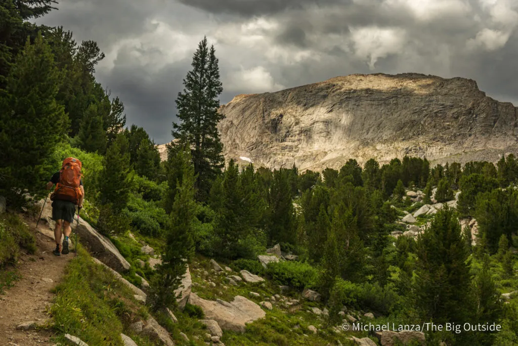 A backpacker hiking the Pyramid Lake Trail in the Wind River Range, Wyoming.