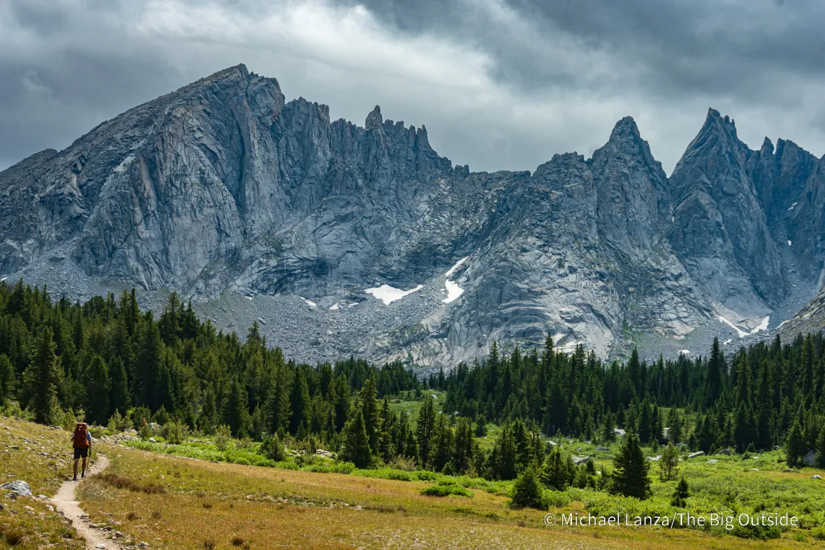 A backpacker hiking the Shadow Lake Trail in the Wind River Range, Wyoming.