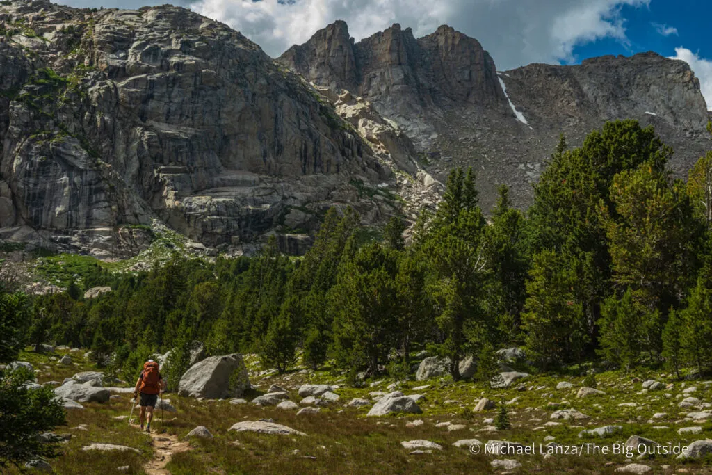 A backpacker hiking the Washakie Pass Trail in the Wind River Range, Wyoming.