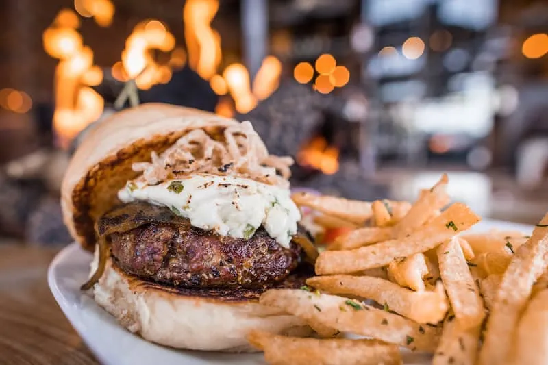 A big juicy burger and fries by the fire during happy hour at Cowboy Star