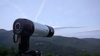 a black and white telescope in a field