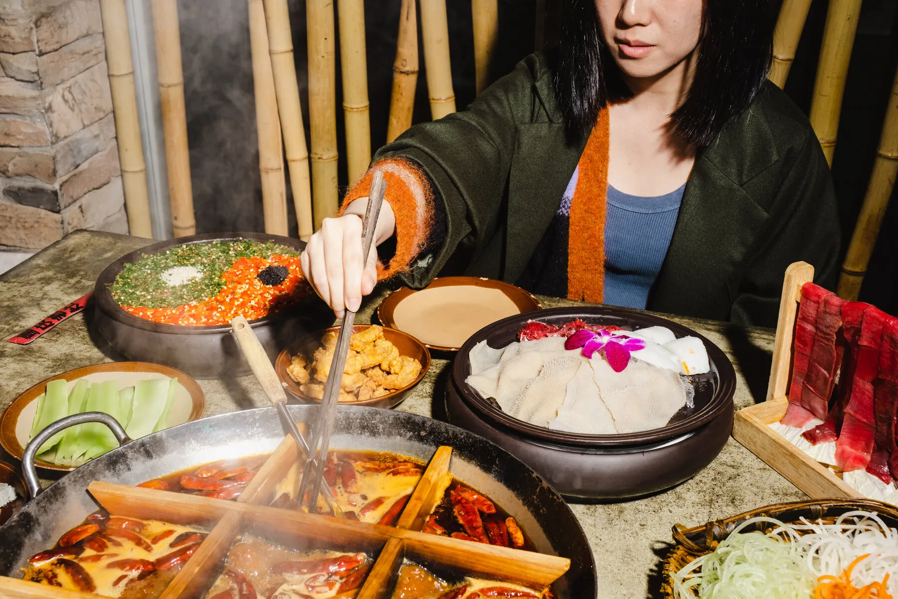 A bubbling hot pot at Chongqing Lao Zao, filled with spicy red broth and ingredients.