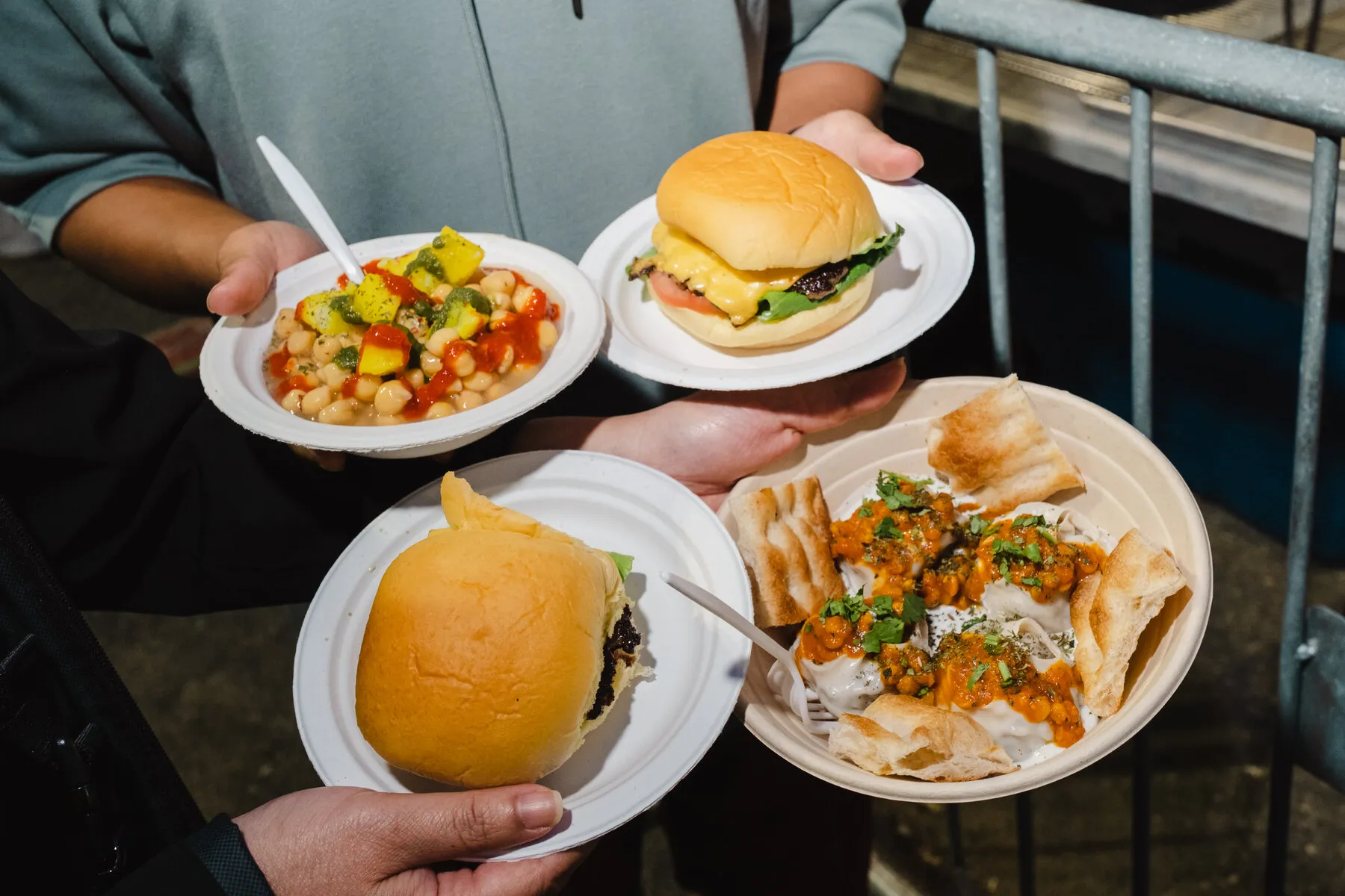 A bustling scene at the Queens Night Market with diverse food vendors and crowds of people, showcasing the market's lively atmosphere and global offerings.
