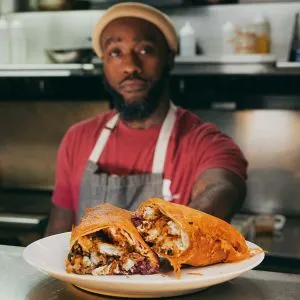 A chef presenting a beautifully plated dish in Portland, known for its vibrant food scene