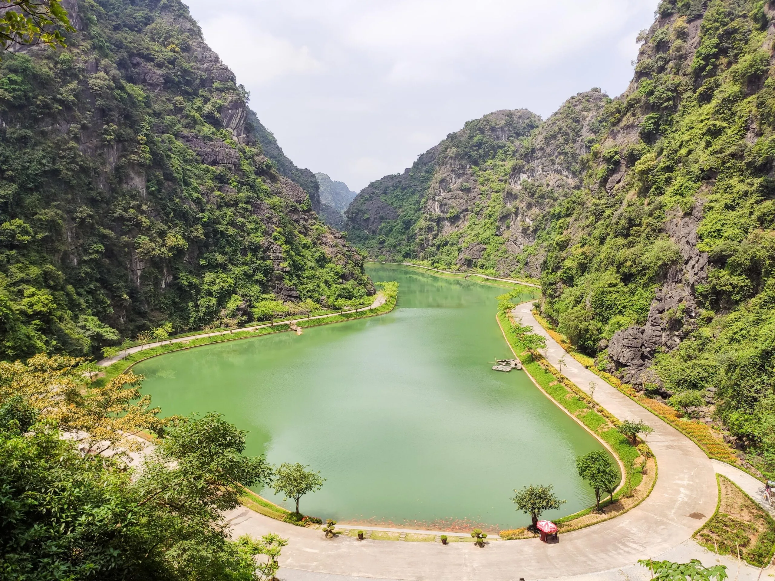 A clear, blue lake surrounded by sheer limestone cliffs, creating a secluded valley