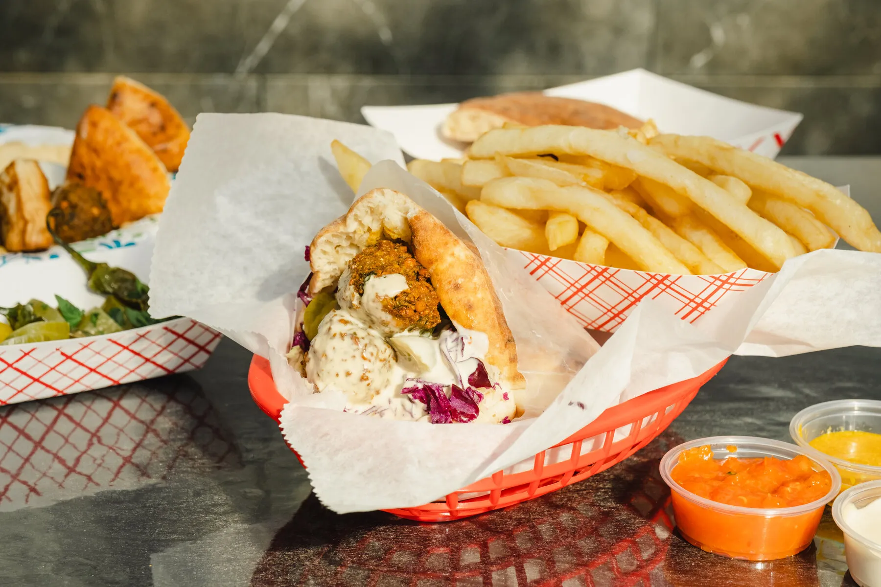 A close-up of a falafel sandwich or plate from Falafel Tanami, showing the bright green interior of the falafel.