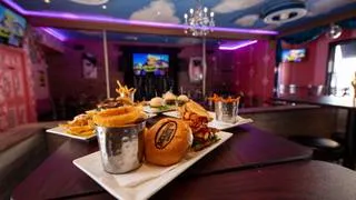 A close-up of a gourmet burger and fries served at Hamburger Mary's, showing the quality of food alongside the entertainment in this Denver restaurant.