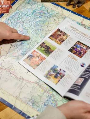 A couple observes a map while planning a trip, a common activity when deciding Wyoming Where To Go