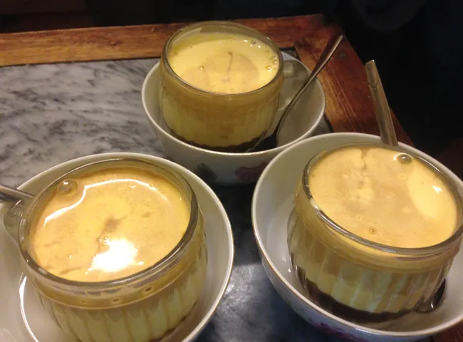 A cup of Cà Phê Trứng with its creamy foam top, a unique Hanoi Specialty Food drink