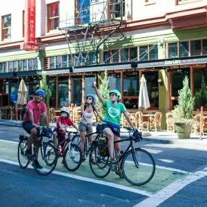 A family bikes on a green bike lane in the city, an enjoyable activity during bike tours in Portland Oregon.