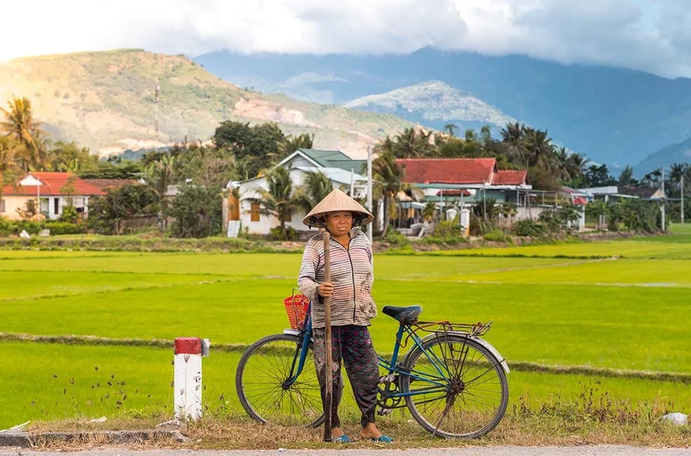 A farmer working in a flooded rice paddy field in Vietnam.