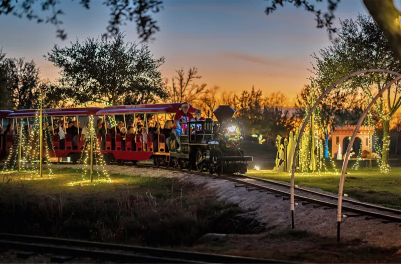 A festive train decorated with Christmas lights