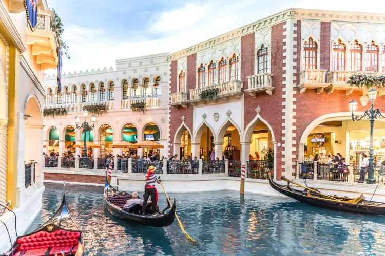 A gondola on the water next to buildings at The Venetian, a classic romantic date idea in Las Vegas