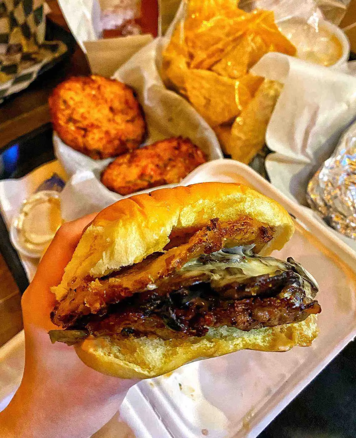 A large burger with fries and a side of queso from JewBoy Burgers in Austin