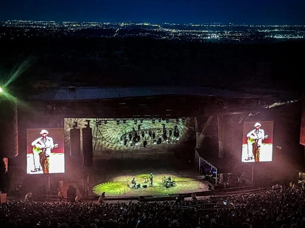A large crowd watching a musical concert at the Red Rocks Amphitheater