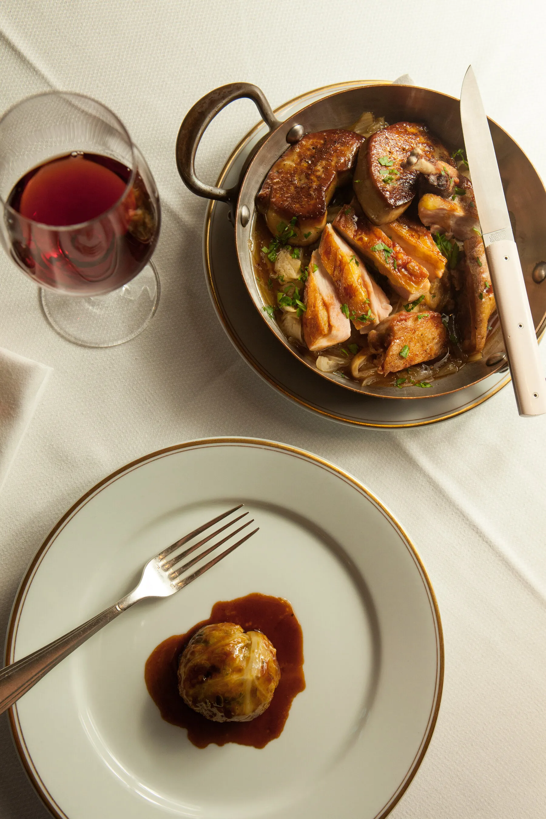 A lavish table setting and French dishes at Le Coucou, conveying the restaurant's elegant and formal dining environment.