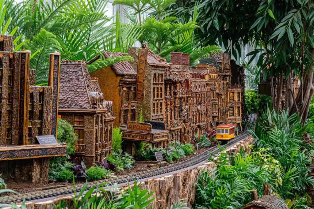 A miniature trolley passing replicas of New York landmarks at the NYBG Holiday Train Show