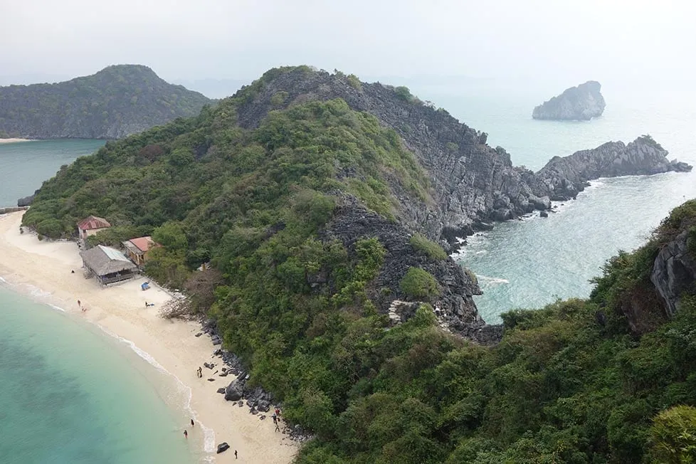 A panoramic view of limestone islands and a boat in Ha Long Bay, Vietnam.