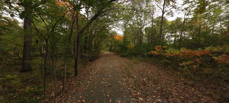 A paved trail running adjacent to a highway embankment, representing the I-275 Metro Trail