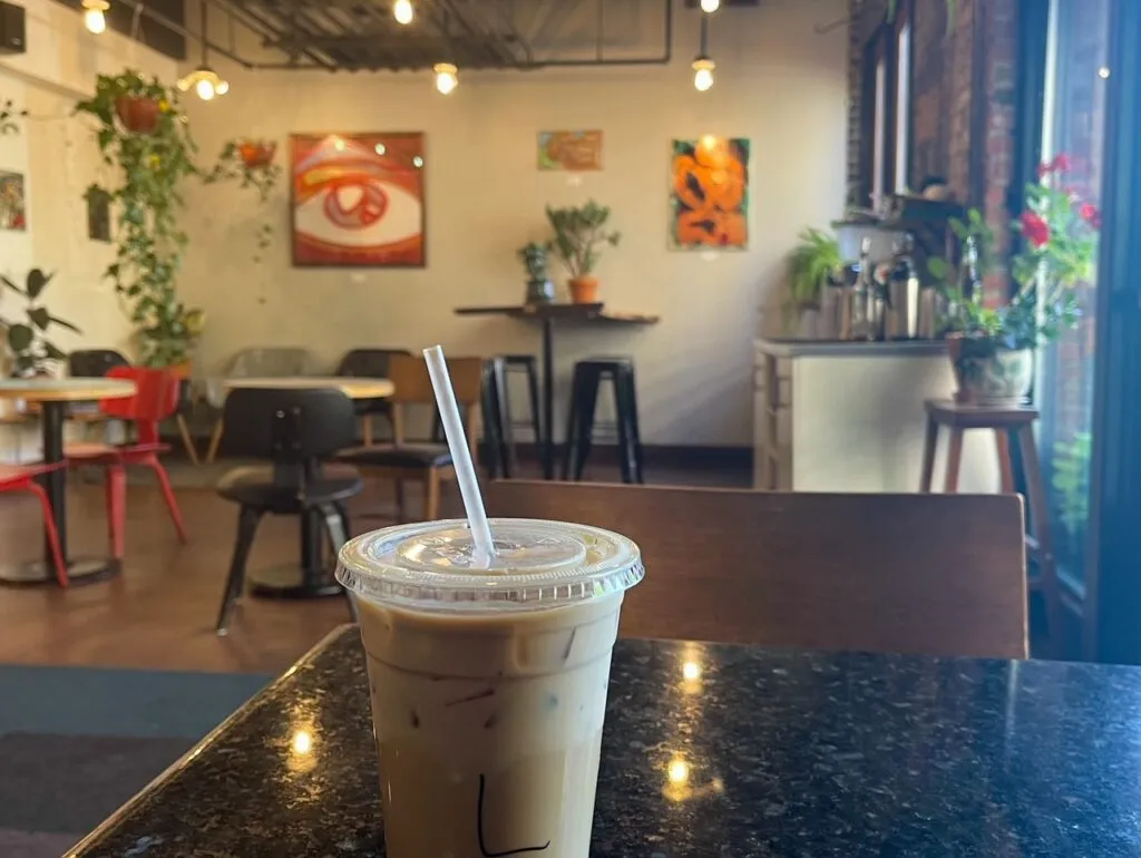 A person enjoying a coffee inside a cozy Denver coffee shop