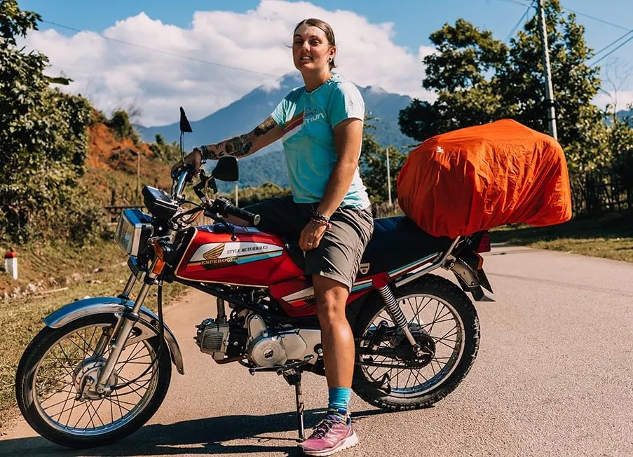 A person wearing a helmet and riding a motorbike on a road in Vietnam, emphasizing safety.