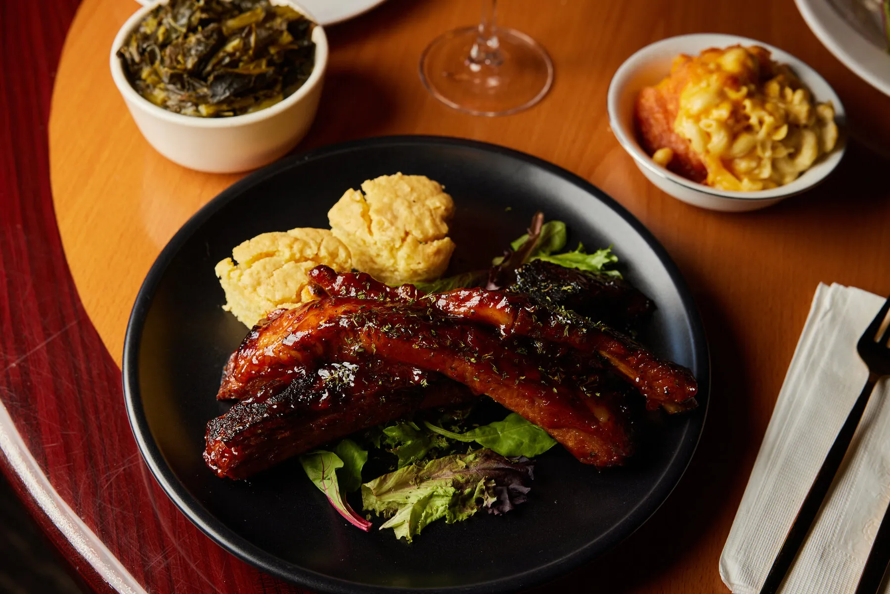 A plate of &quot;soul fries&quot; from Shaw-naé's House, showing the layers of mac and cheese, fried chicken, and collard greens over fries.