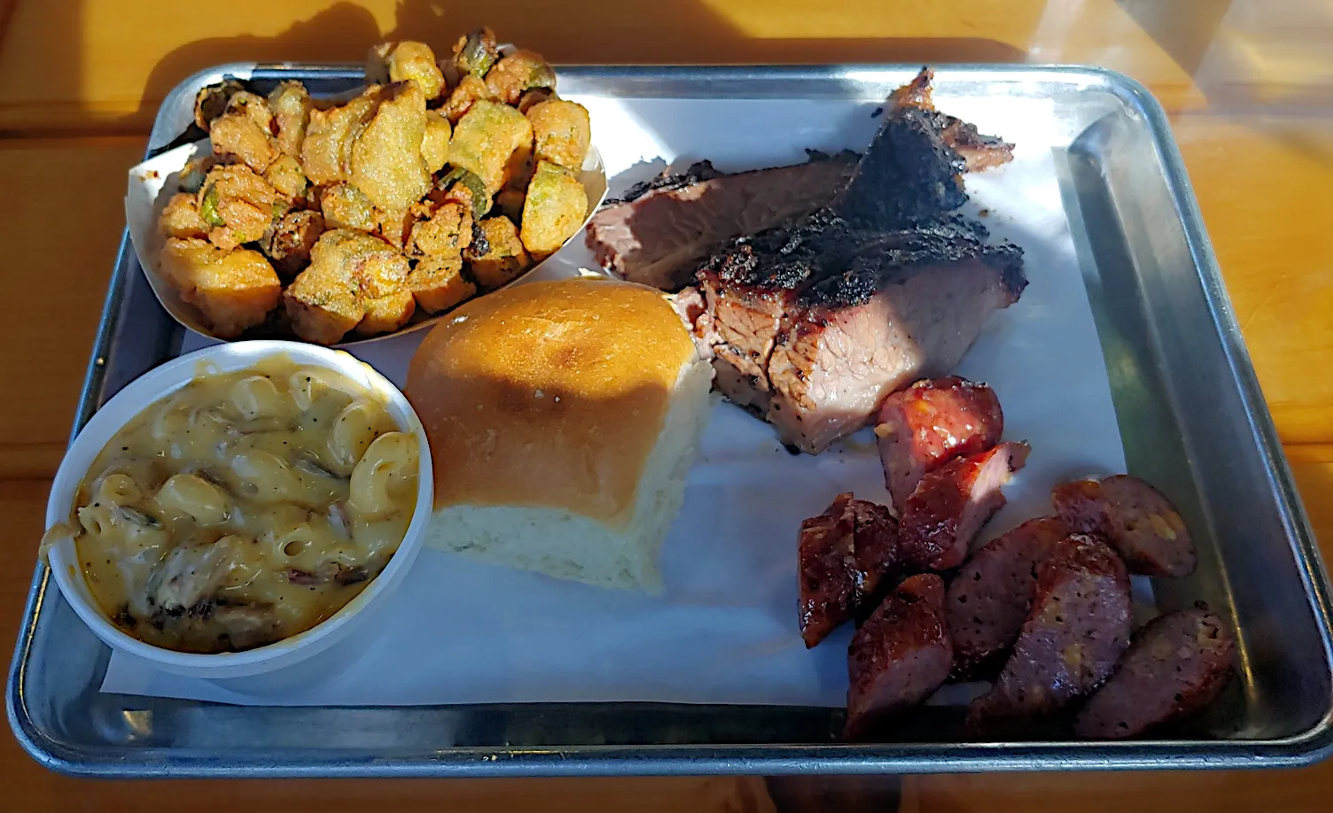 A plate with sliced meat and sausage links