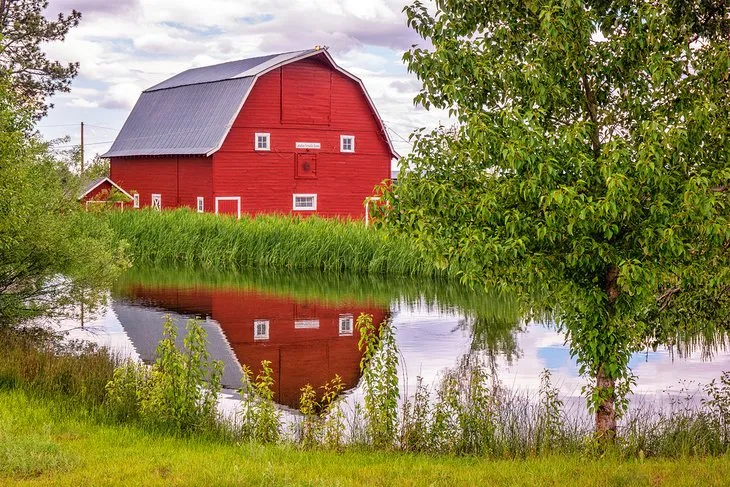 A rustic barn stands against a backdrop of mountains near Sisters, Oregon