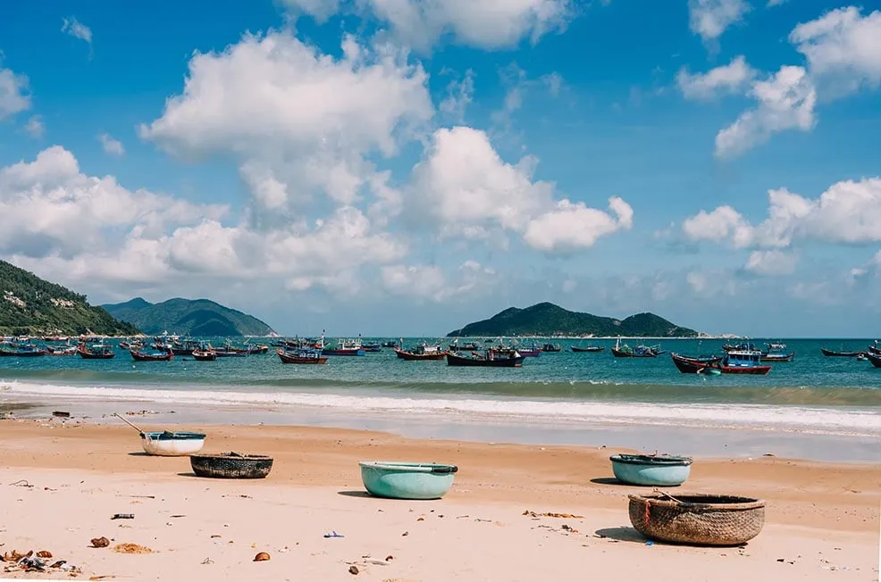 A sandy beach and palm trees along the coastline of Nha Trang, Vietnam.