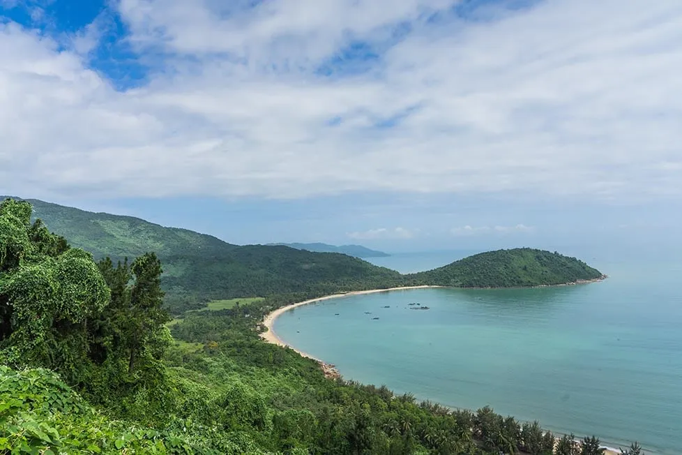 A scenic view of the Vietnamese coastline with lush green mountains meeting the sea.