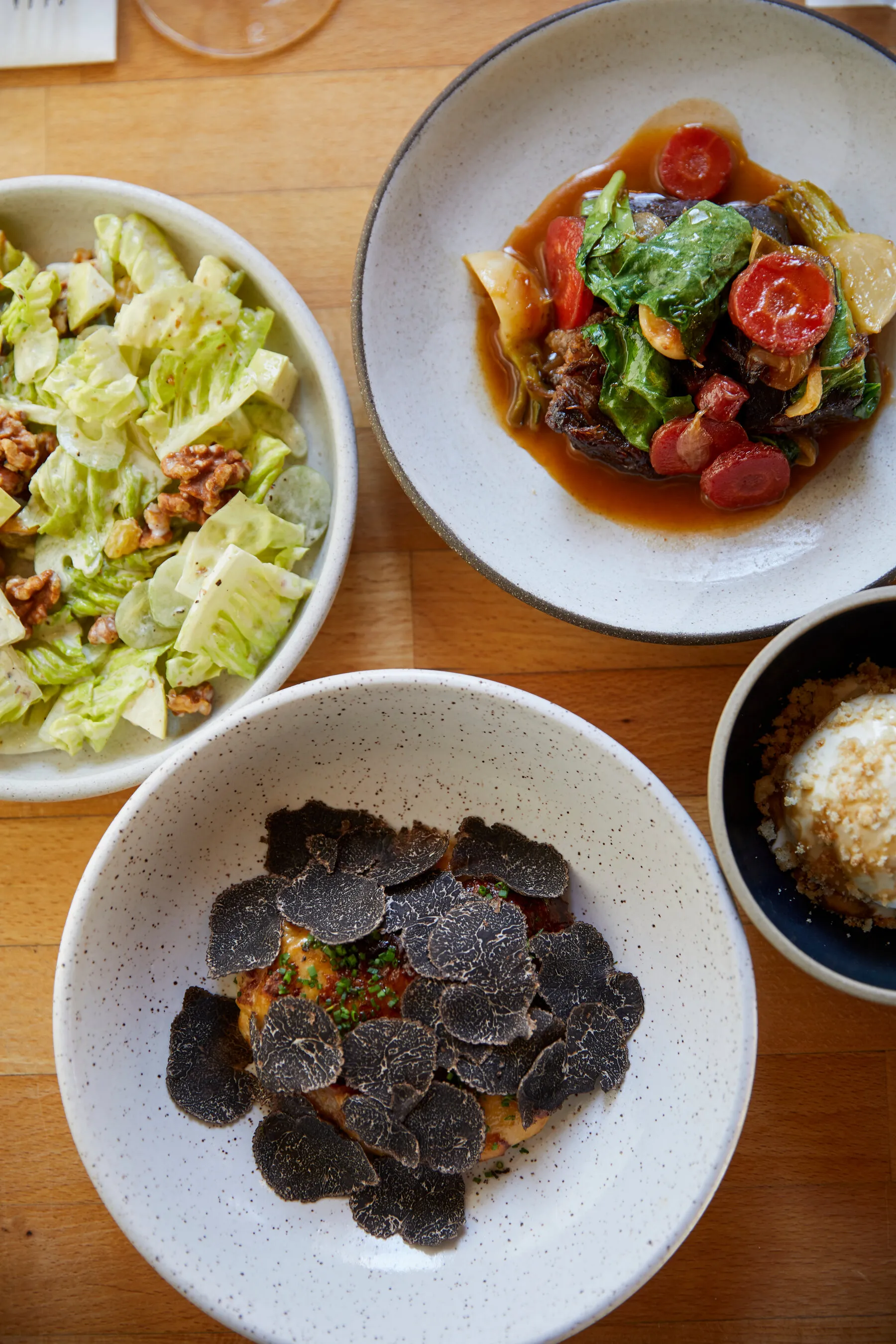 A selection of dishes from The Four Horsemen, showcasing modern American cuisine with simple, elegant plating.