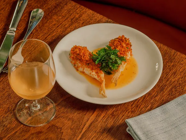 A selection of French brasserie dishes from Frenchette, presented on a marble tabletop.
