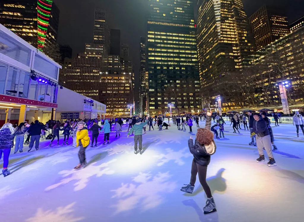 A skater falling on the ice at Bryant Park's Christmas rink