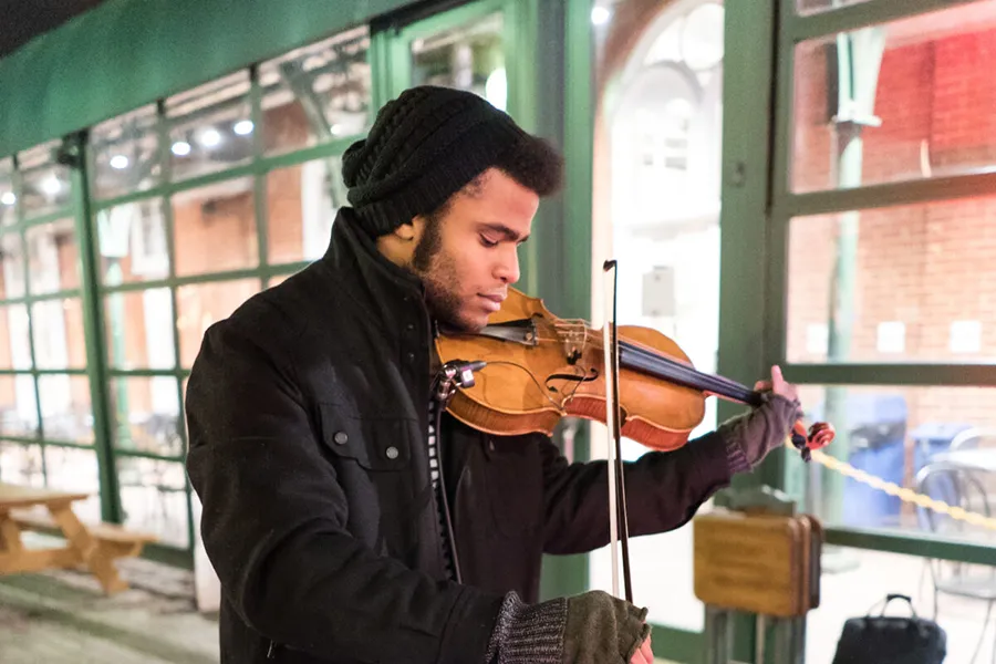 A street performer playing violin during the Georgetown Jingle holiday event