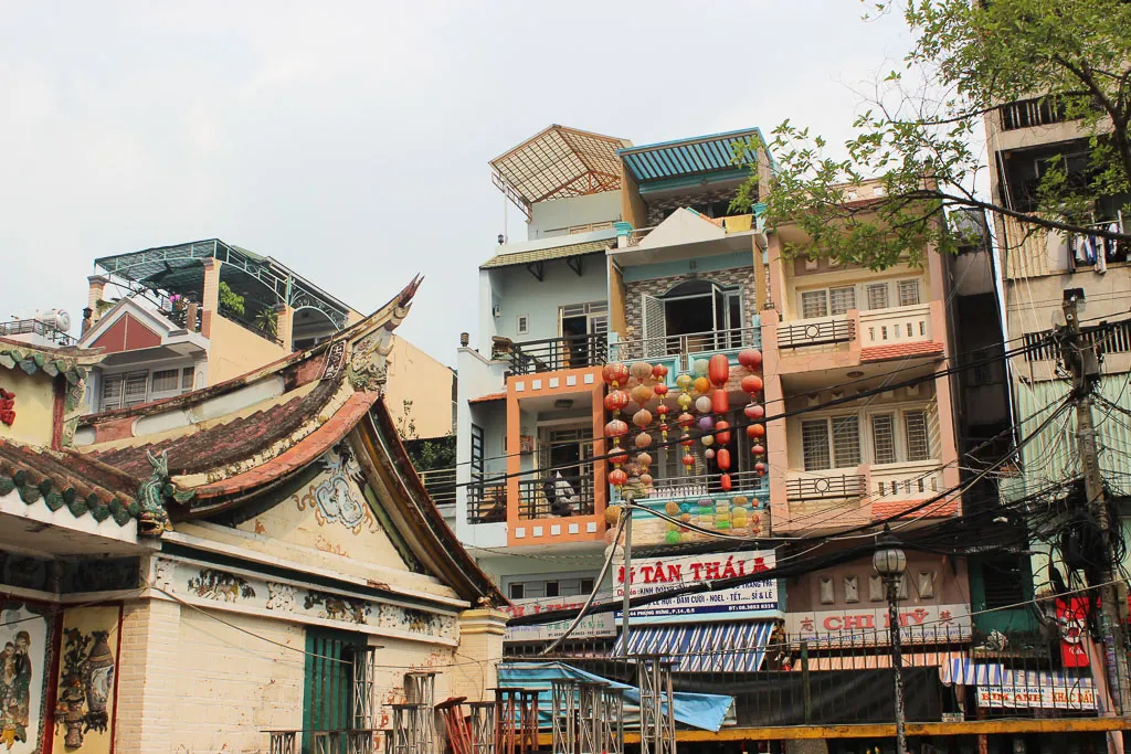 A street scene in Cholon (Saigon's Chinatown) featuring red lanterns and bustling activity