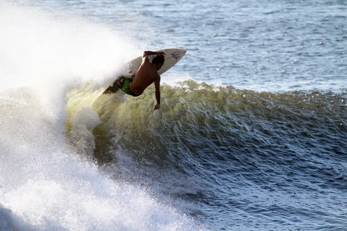 A surfer riding a wave in the ocean off the coast of Haleiwa, Oahu.