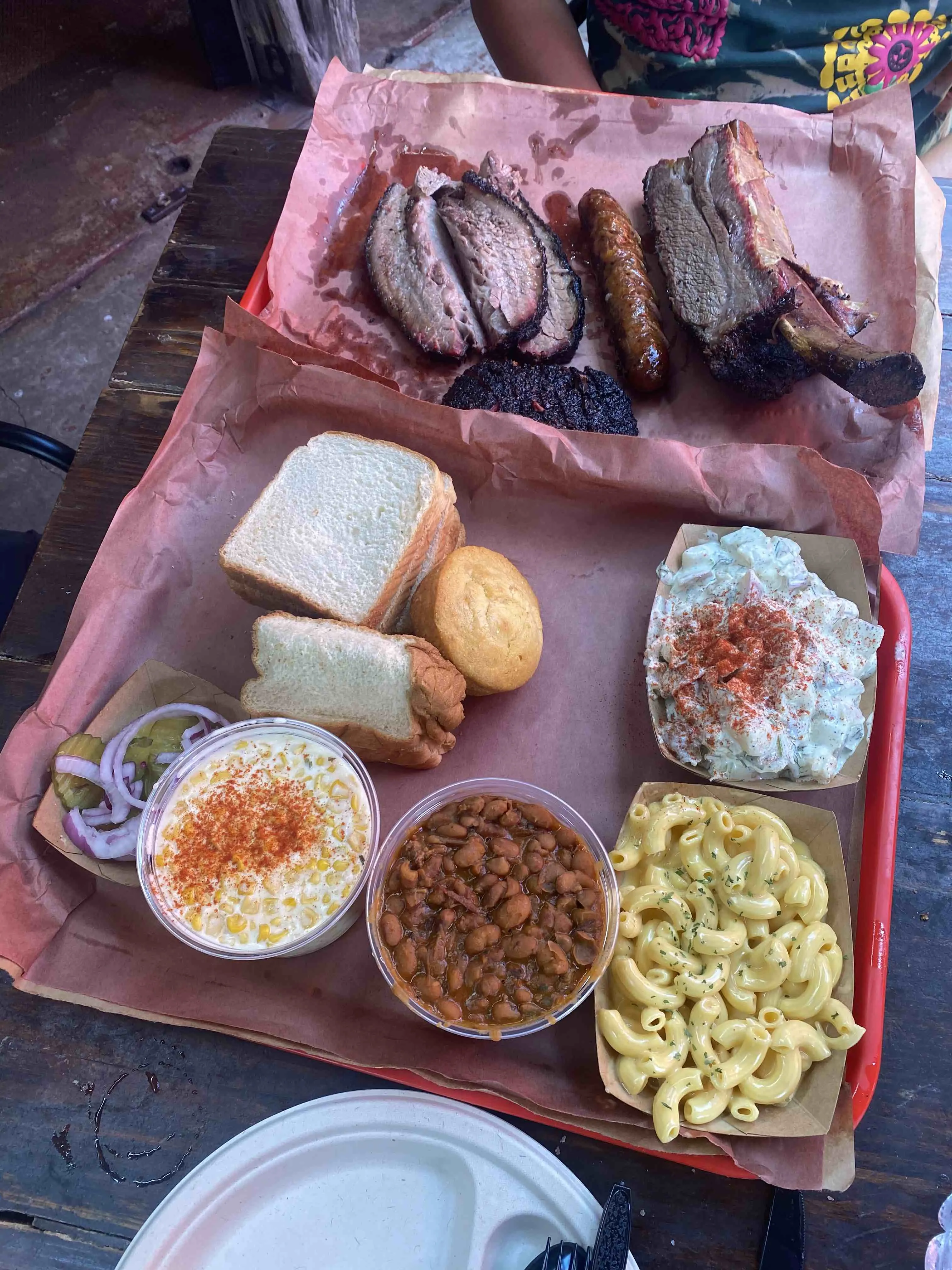 A tray loaded with various cuts of smoked meat and sides at Terry Black's Barbecue in Austin