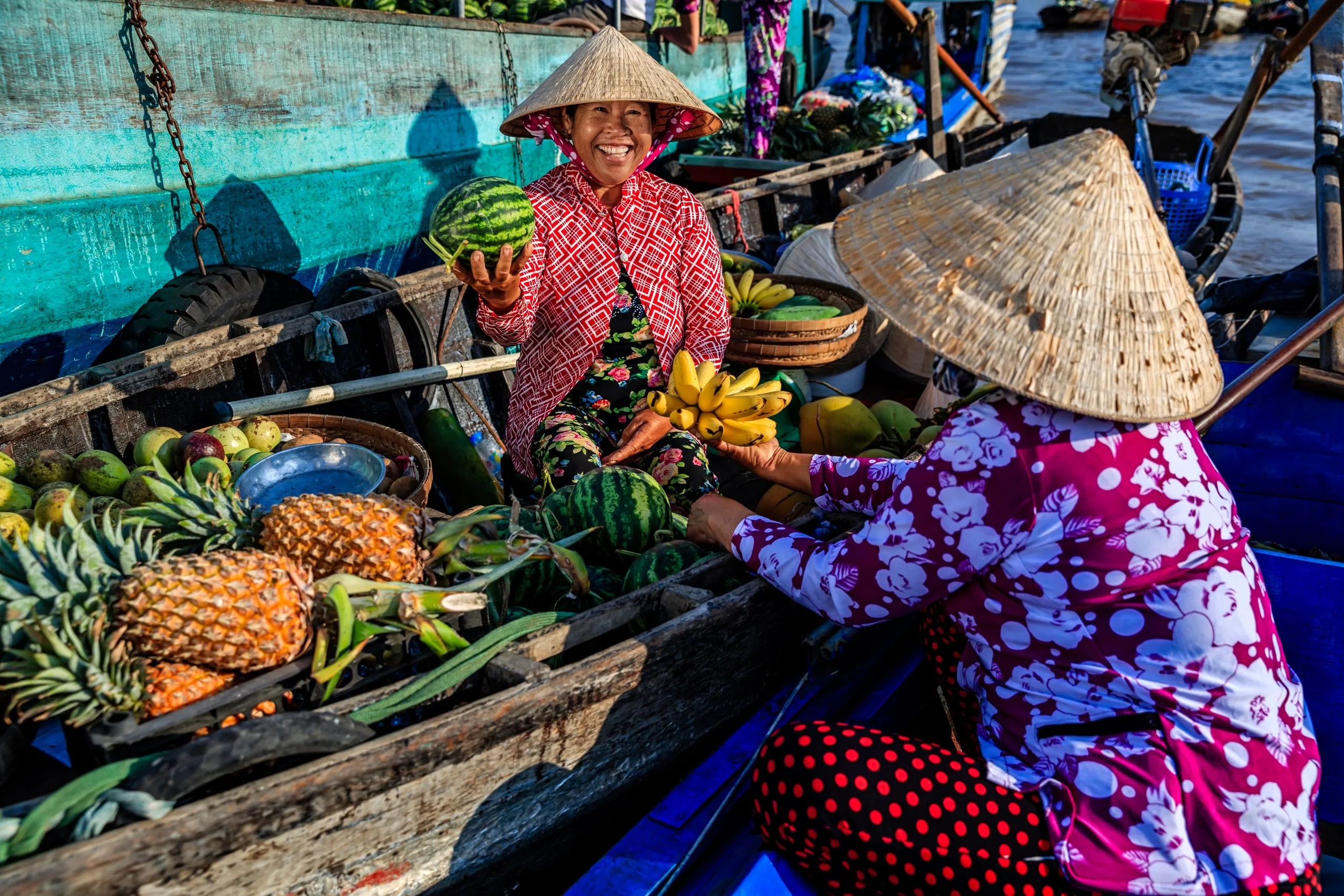 A vendor selling fresh fruit from their boat at a bustling floating market on the Mekong Delta, showcasing the unique riverine lifestyle in Vietnam.