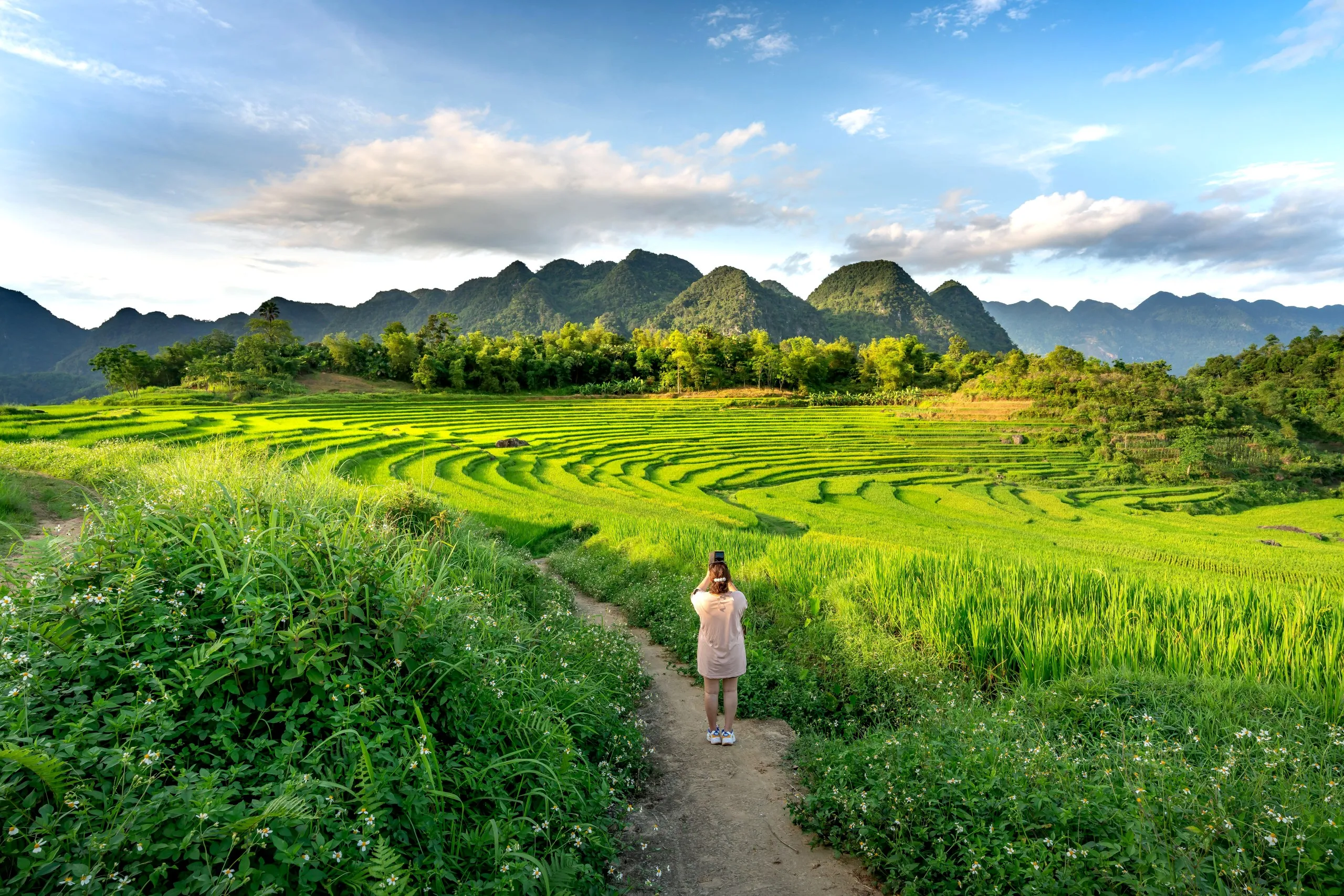 A visitor capturing the serene beauty of the tiered rice terraces in Pu Luong nature reserve, a picturesque destination in Vietnam.