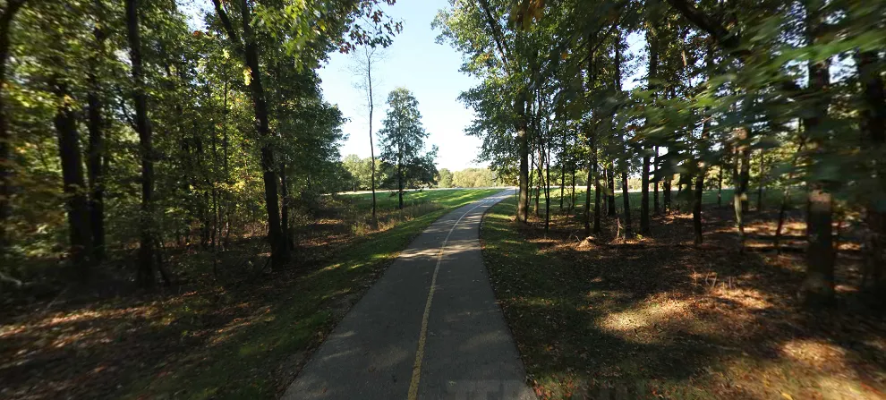 A wide paved loop trail around a lake at Stony Creek Metropark, popular for hiking and biking