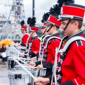 A youth drum line marching band performing in the Portland Rose Festival parade