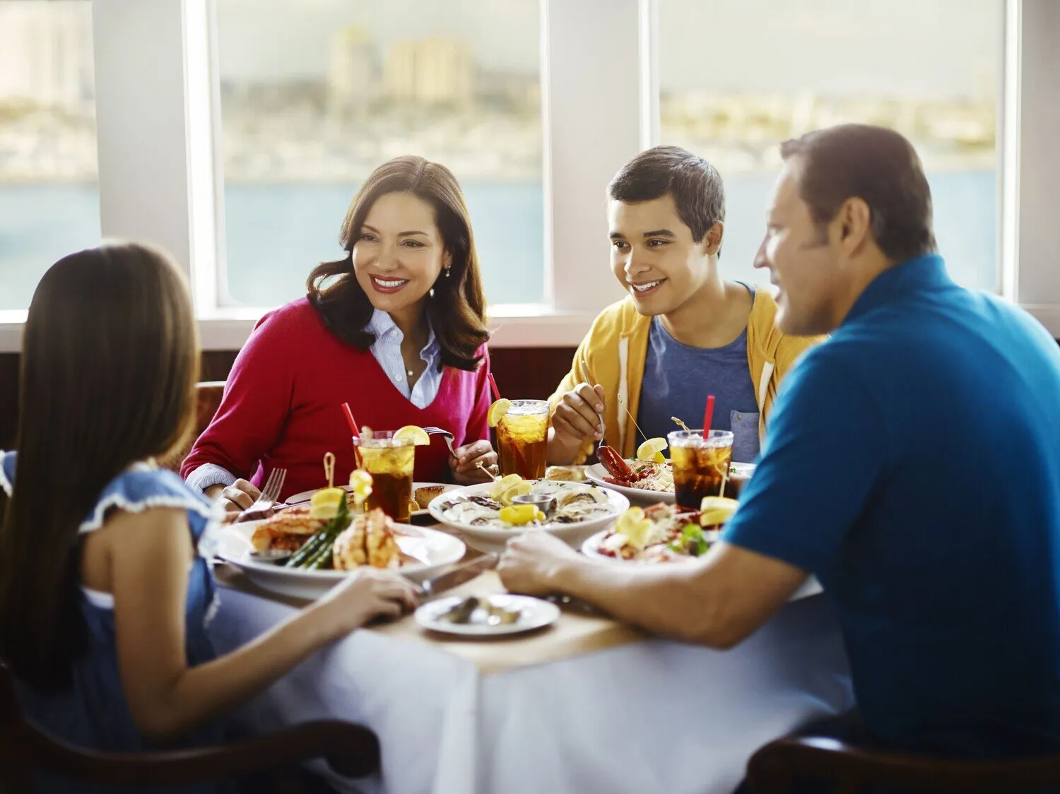 alt text: A group of people enjoying a meal in a historic dining room aboard The Queen Mary.