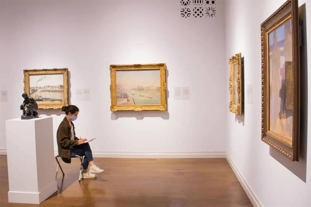 An adult sketching class taking place in a courtyard at the Honolulu Museum of Art