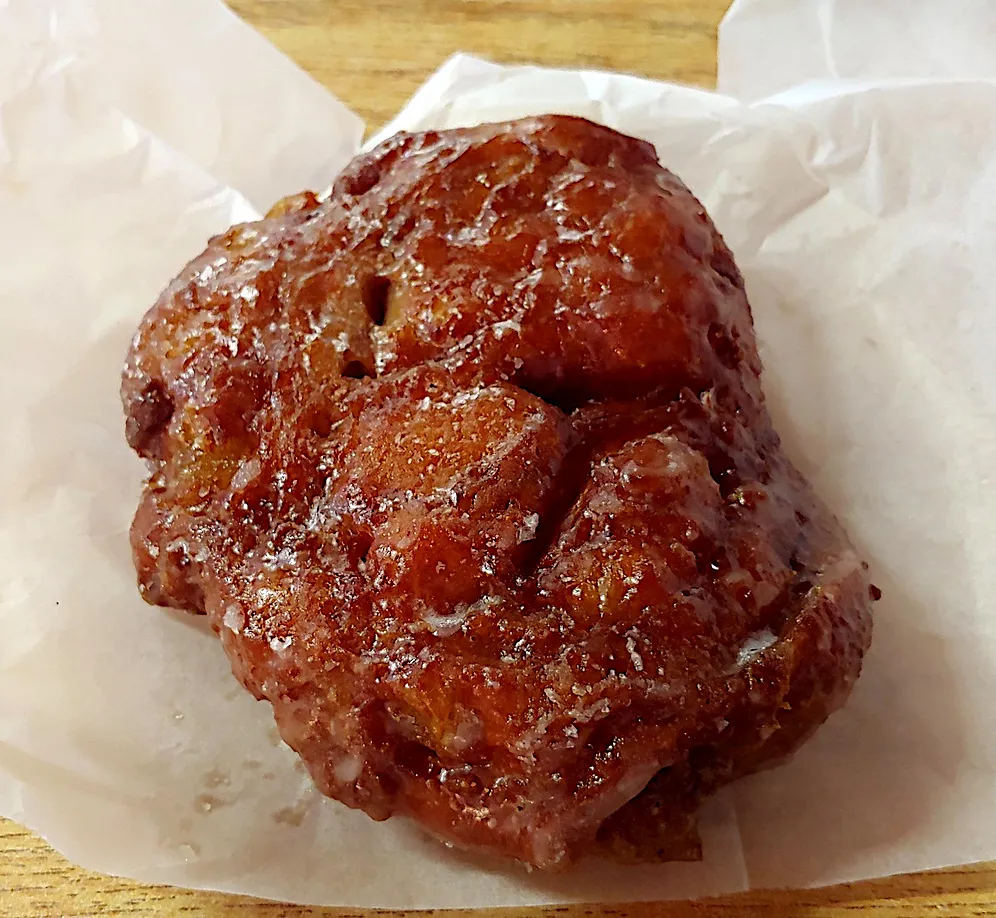An apple fritter on a small plate