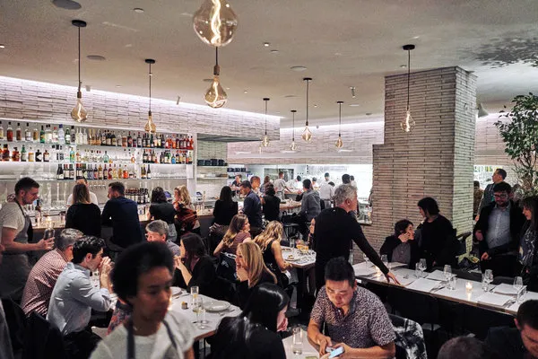 An interior view of Misi, showing the open kitchen area where pasta is made behind glass.