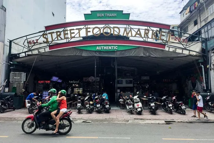 An outdoor street food market with many stalls and seating areas