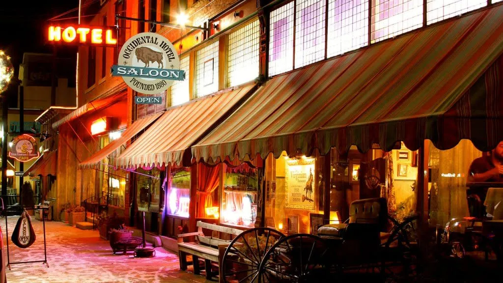 An outside view of the Historic Occidental Hotel Museum with various historic artifacts outside and a sign that reads, 